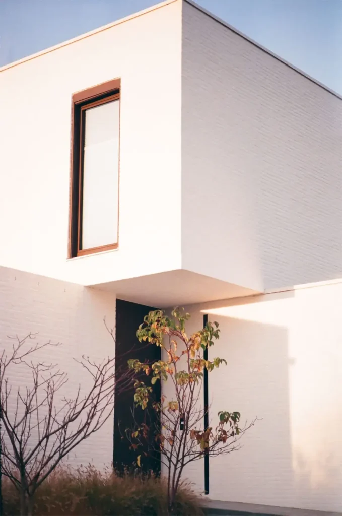 chassis pvc vertical sur mesure teinte bois facade blanche architecture contemporaine