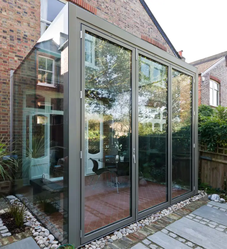 extension vitree aluminium sur maison en briques